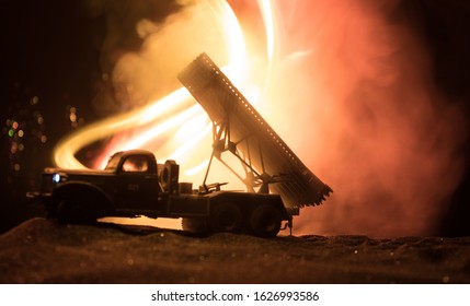 Rocket launch with fire clouds. Battle scene with rocket Missiles with Warhead Aimed at Gloomy Sky at night. Soviet rocket launcher on War Background. Creative composition.