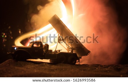Rocket launch with fire clouds. Battle scene with rocket Missiles with Warhead Aimed at Gloomy Sky at night. Soviet rocket launcher on War Background. Creative composition.