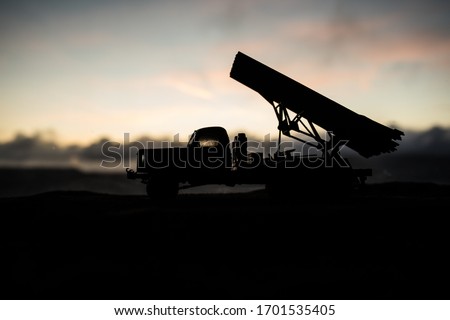 Rocket launch with fire clouds. Battle scene with rocket Missiles with Warhead Aimed at Gloomy Sky at sunset. Soviet rocket launcher on War Background. Creative composition.