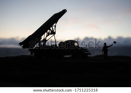 Rocket launch with fire clouds. Battle scene with rocket Missiles with Warhead Aimed at Gloomy Sky at sunset. Soviet rocket launcher on War Background. Creative composition.