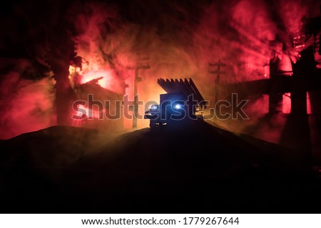Rocket launch with fire clouds. Battle scene with rocket Missiles with Warhead Aimed at Gloomy Sky at night. Soviet rocket launcher on War Background. Creative composition.