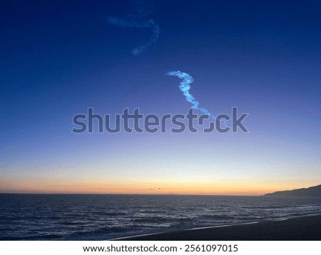 Rocket launch trail at the beach at sunset.
