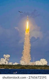 Rocket is launched, creating a dramatic explosion of smoke and fire against a clear blue sky amidst a snowcovered ground. Rocket cloud. Billow of smoke. Elements of this image furnished by NASA