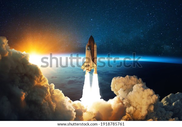 Rocket lift off. Space shuttle with smoke and blast
takes off into space on a background of blue planet earth with
amazing sunset. Successful start of a space mission. Travel to
Mars