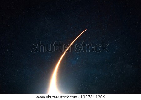 Rocket with a light blast flies and takes off into space in the starry sky. Spaceship launch on a dark background, concept. 