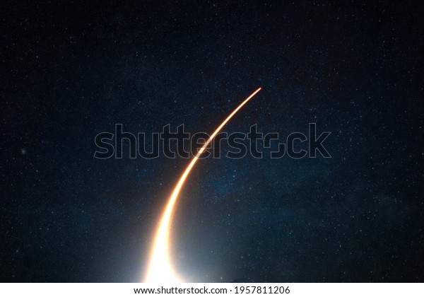Rocket with a light blast flies and takes off into space\
in the starry sky. Spaceship launch on a dark background, concept.\
