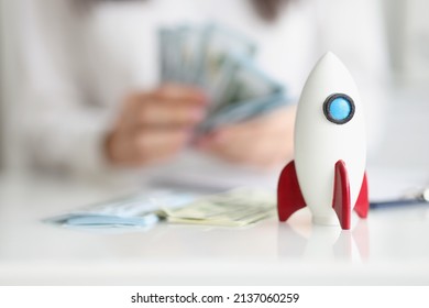 Rocket model on desk, rocketship symbol for startup, earn money on beneficial project