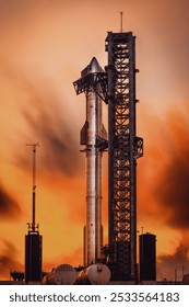 A rocket on a launch pad at sunset, with an orange sky and clouds in the background, capturing the moment before liftoff.