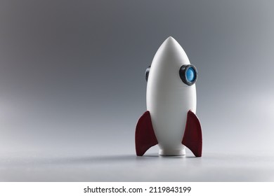 Rocket toy model stand on grey surface, rocketship as symbol for business project