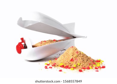 Rocket-type feeder feeder with bait inside, white on a white background, bait slide in the foreground, front view close-up isolate