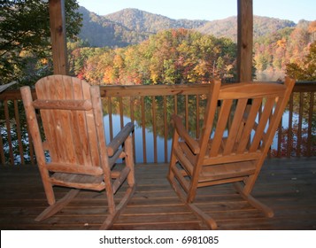Rocking chairs on a porch overlooking lake in North Carolina mountains.