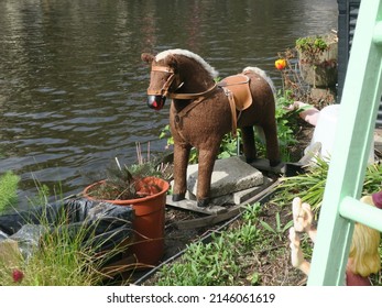 a rocking horse in a tiny garden near a canal in Amsterdam