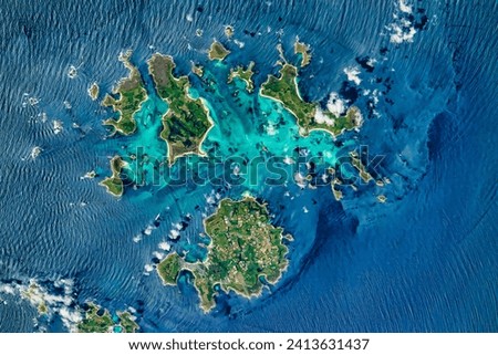 Rocking the Isles of Scilly. Shallow rock formations and sandbars allow people to occasionally walk between the islands. Elements of this image furnished by NASA.