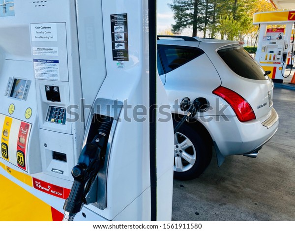 Rocklin, CA - November 16, 2019: Car getting\
gas at a Shell station. Higher gas prices are slowing down sales of\
SUV and larger vehicles in California.\
