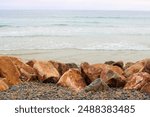 Rocks besides pebbles on the Southern California Coast at a secluded beach cove overlooking the Pacific Ocean taken in Oceanside, CA 