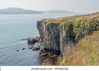 Rocks, cliffs, cold sea spikelets and blue sky