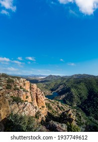 Rocks with layers, mountain range and dam