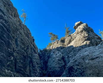 Rocks and paths between the rocks in the area of ​​Strzeliniec peak (905 m above sea level) in the Stolowe Mountains National Park in Poland.