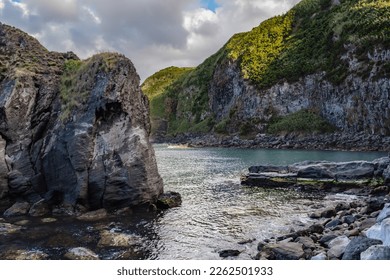 Rocks, stone and cliff mount in lowlight evening with ocean water in Port of Santa Iria, São Miguel - Azores PORTUGAL