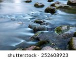 Rocks in stream with smooth flowing water