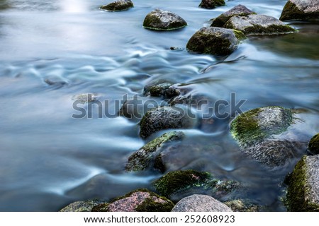 Rocks in stream with smooth flowing water