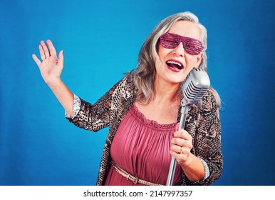 The Rockstar In You Lives Forever. Portrait Of A Funky And Cheerful Senior Woman Singing On A Microphone In Studio.