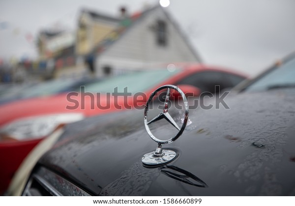 Rockville, Maryland / USA - Dec. 9, 2019:\
A car with a Mercedes star emblem is parked in the lot of a used\
car dealership on a rainy afternoon in the\
wintertime.