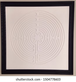 Rockwall, TX USA- September 14, 2019: Framed wall labyrinth for home decor designed after the labyrinth in Chartres Cathedral in France; finger used to trace the labyrinth