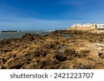 The rocky Atlantic coast and the fortified walls of the coastal city of Essaouira. Morocco, Africa