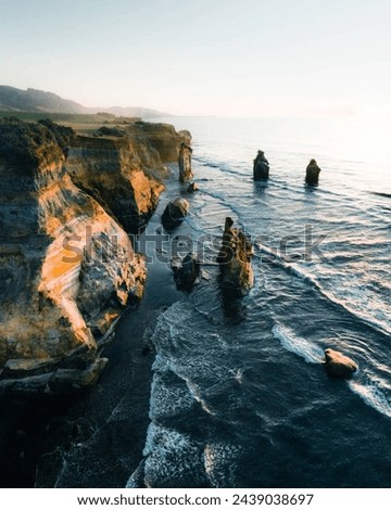 A Rocky Beach With A Cliff and Ocean In New Zealand 