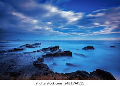 Rocky beach illuminated by full moonlight during the blue hour: Twilight in Mooloolaba, Queensland, Australia - Powered by Shutterstock