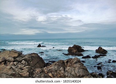 Rocky beach on a cloudy day. rocky seashore. Rocky beach shoreline with turquoise water and cloudy sky. Turquoise water with rocky beach background. Blue ocean waves. beach background. sstkSummer - Powered by Shutterstock