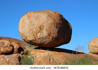 Rocky boulder in Australian outback below a blue and sunny clear sky