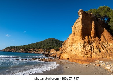 Rocky clay seashoe and the beach of Sa Caleta. Ibiza. Spain.