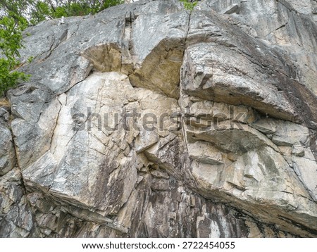 Rocky cliff with layered strata and angular fractures; a natural coastal scene. West Coast Shore in British Columbia, Canada
