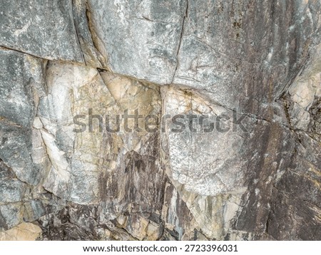 Rocky cliff with layered strata and angular fractures; a natural coastal scene. West Coast Shore in British Columbia, Canada