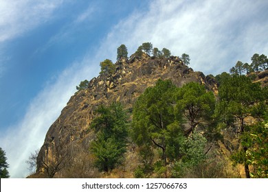 Rocky cliff in the Sivalik mountains, Lesser Himalaya. Selected Himalayan pine trees on the mountainside, springtime - Shutterstock ID 1257066763