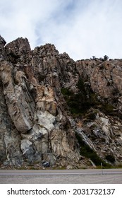 Rocky cliff walls by the road, Amazing rock formations above the road, with cracks, crevices and slopes Beautiful view