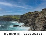 Rocky cliffsides, some covered in vegetation,  dropping to the Pacific Ocean on the shoreline of Maui in Wailuku