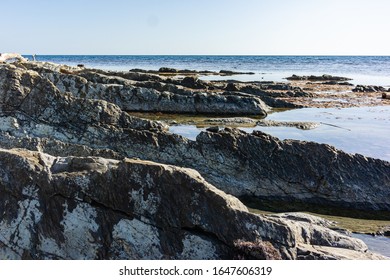 Rocky coast of Black Sea in village of Olginka, Tuapse district. Steep rocky slopes are composed of natural textures. Close-up. Fragments of rock of various sizes go into depths of sea. - Powered by Shutterstock