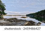 Rocky coast and view of boats in the harbor at dusk Bar Harbor, Maine, USA