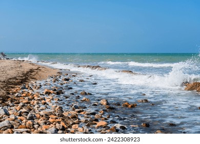 Rocky coastline. Sea wave background breaking sea water rocky shore rough turquoise water at Rimini, Italy. Seascape with sea horizon and clear deep blue sky. - Powered by Shutterstock