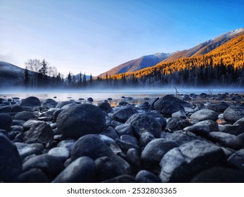 Rocky foreground with a misty lake and vibrant, sunlit mountain ridges, surrounded by evergreen trees and a serene, clear sky. - Powered by Shutterstock