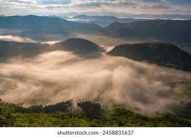 Rocky, forested hill emerges from the valley in the mist. Beautiful morning in the mountain landscape with mists. Morning fog. Sulovske skaly, Velky Manin Povazie - Powered by Shutterstock