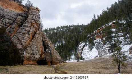 Rocky mountain cliffs outside of Arizona's Flagstaff, with snowy pine trees in view, in Coconino County and National Forest, close to Sedona and the border with Utah, cloudy skies, March 2024. - Powered by Shutterstock