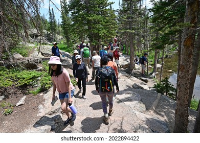 Rocky Mountain National Park, Colorado - July 26, 2021 - Visitors hike on crowded Emerald Lake Trail on sunny summer morning.
