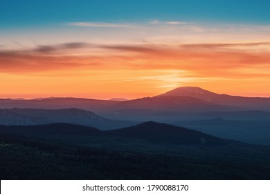 A rocky mountain range covered in the wild woods illuminated by the golden light of the setting sun. A natural Park reserve or hunting grounds. Recreational outdoor tourism - Powered by Shutterstock