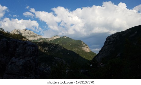 Rocky mountains of Herzegovina lit by sunlight in the background and in the shadows in the foreground.