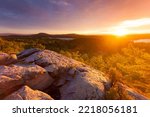 Rocky mountaintop overlooking Lake Dunmore and forest at sunset during autumn