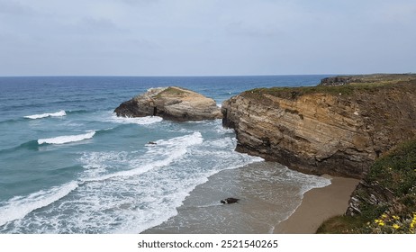 Rocky outcrop, Gentle waves, Sandy beach, Coastal scenery, Serene horizon, Cliffside beauty, Turquoise waters, Rugged shoreline, Sunlit landscape, Ocean breeze, Peaceful retreat, Scenic beach. - Powered by Shutterstock